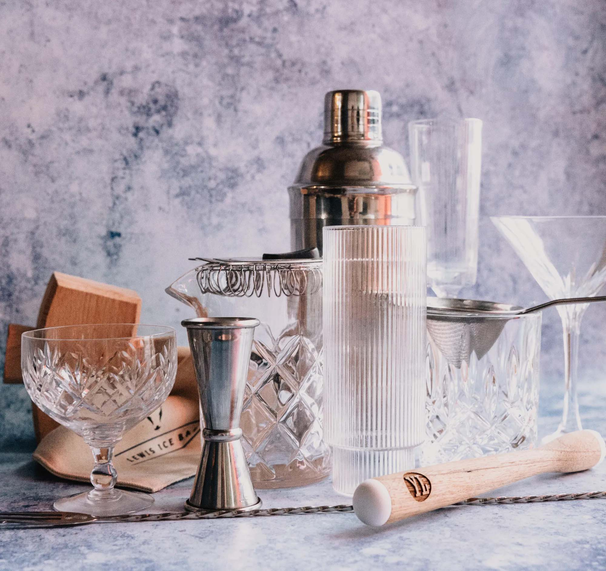 cocktail glasses, a drink shaker, and other bartending supplies
