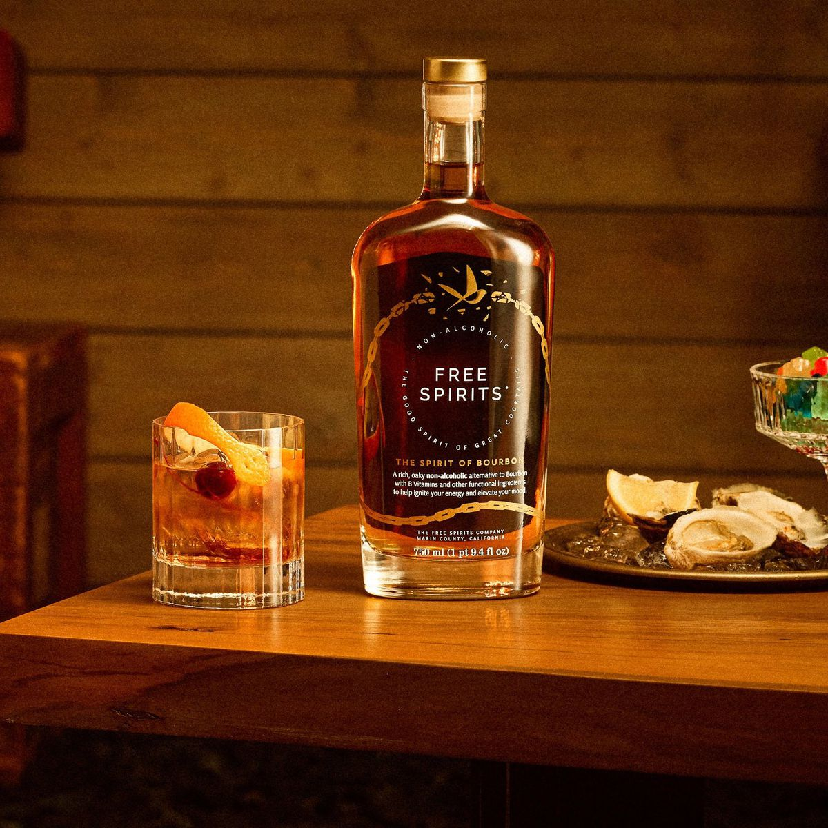 Free Spirits spirit bottle with cocktail and oysters set next to it