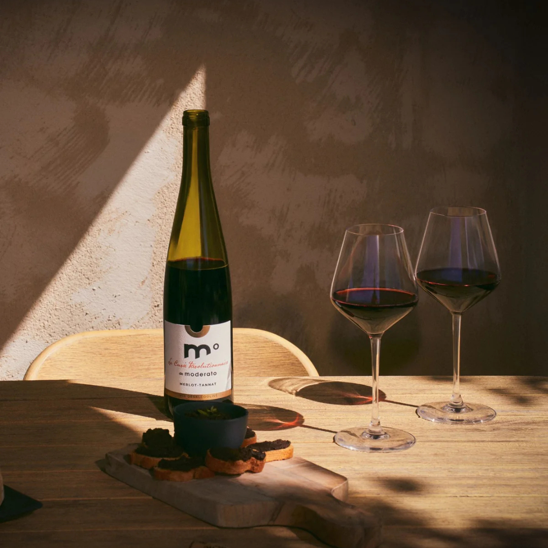 Wine bottle with two glasses of red wine on a wooden table