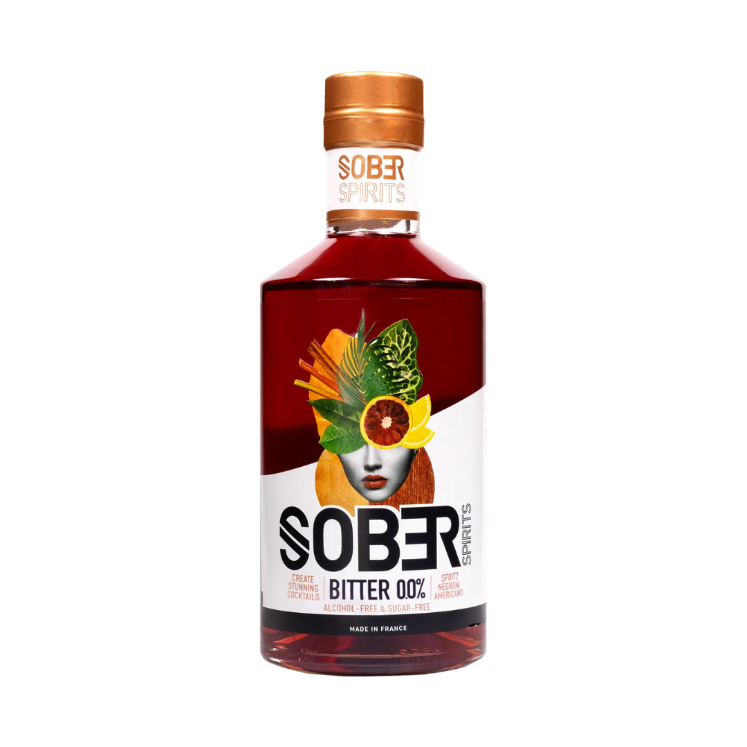 Sober Spirits Bitter 0.0% non-alcoholic aperitif in a 500ml bottle with copper cap and artistic label featuring a collage of citrus, flowers, and a woman's face. Label reads "Alcohol-Free & Sugar-Free" with suggested cocktails like Spritz and Negroni. Made in France.