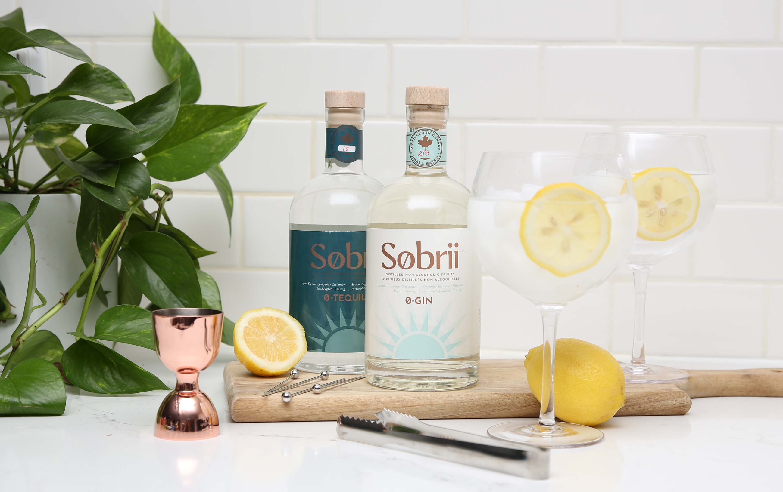 Sobrii non-alcoholic spirits bottles next to cocktails and lemons